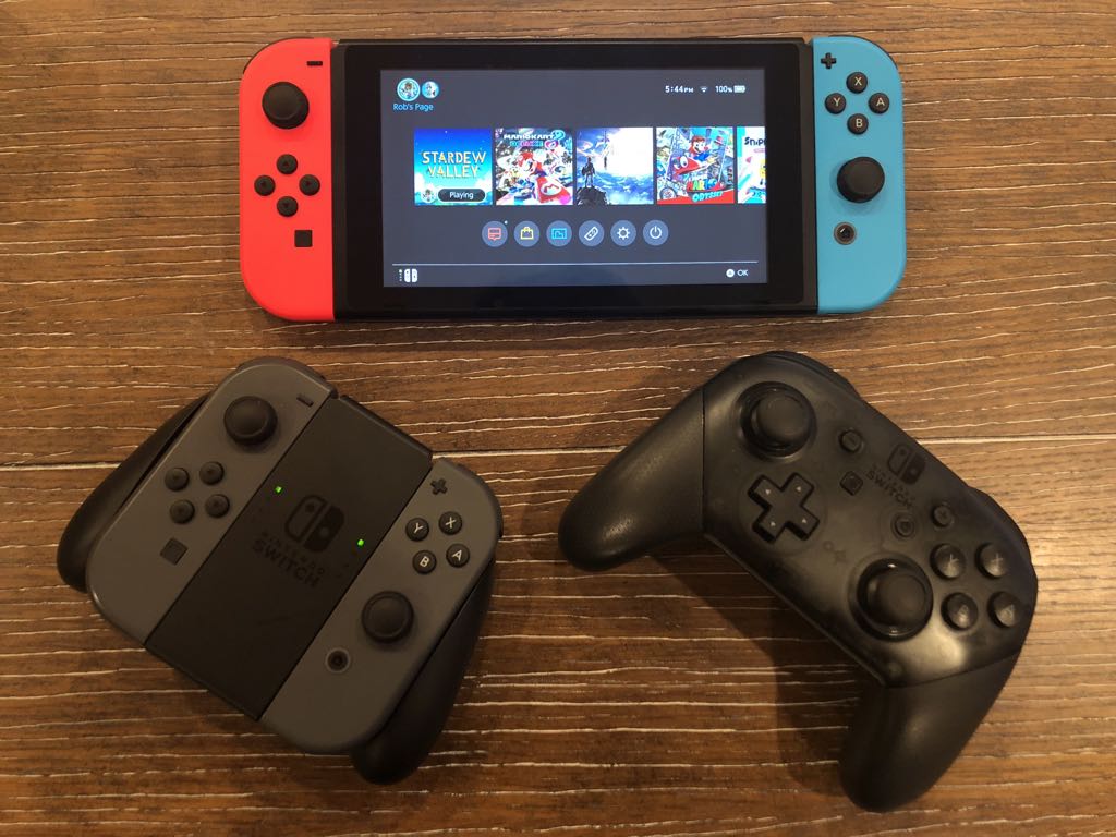 The Nintendo Switch with 2 controllers in front of it